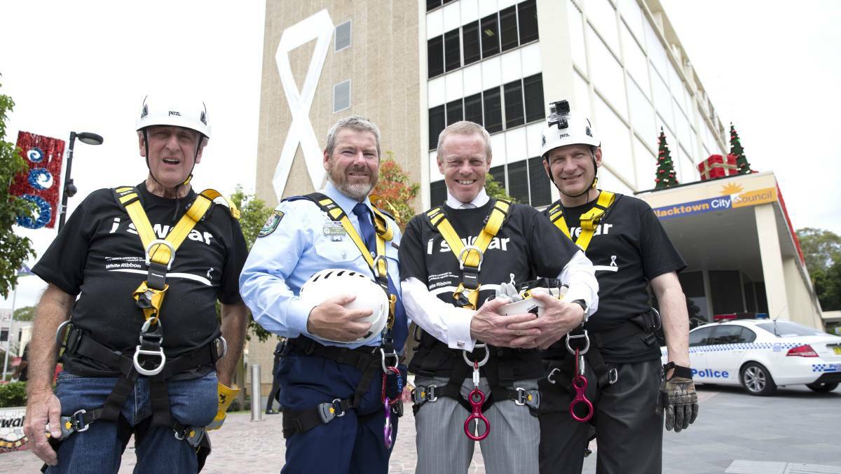 BIG MESSAGE: Councillor Walter Smith, superintendent Gary Merryweather, mayor Stephen Bali and Blacktown Council general manager Kerry Robinson abseiled down the Civic Centre to promote White Ribbon Day in 2014. Picture: Geoff Jones