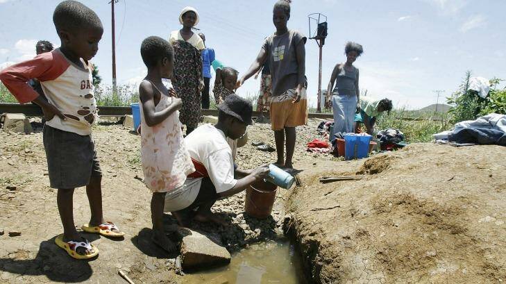 Invisible labour: Zimbabwean women and children fetch water from a well.