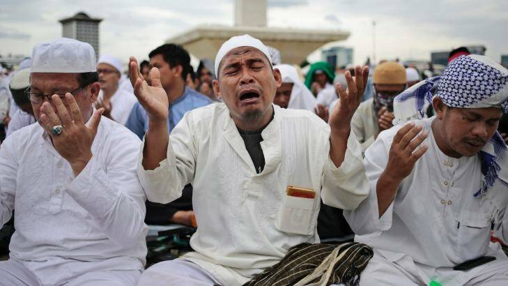 A Muslim man weeps as he prays during the rally on Friday.  Photo: Dita Alangkara