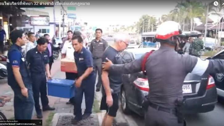 An elderly bridge player is arrested by a Thai policeman in Pattaya. Photo: Youtube