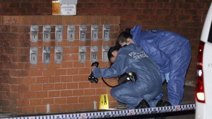Forensic police photograph the scene outside the unit block. Photo: Wolter Peeters