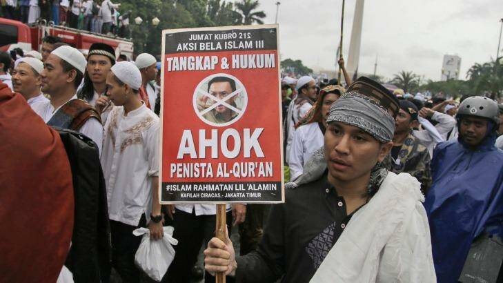 A man holds a poster during a rally against Jakarta's minority Christian Governor Basuki "Ahok" Tjahaja Purnama. Photo: Dita Alangkara