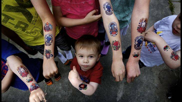 Erik Mosley stands underneath his brothers and sisters who are all wearing temporary tattoos. Photo: Simon O'Dwyer