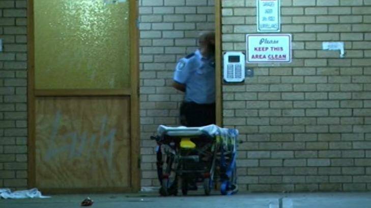 A police officer waits to help Khondkar Fahi Elahi onto a stretcher after she was stabbed in the chest. Photo: Nine News