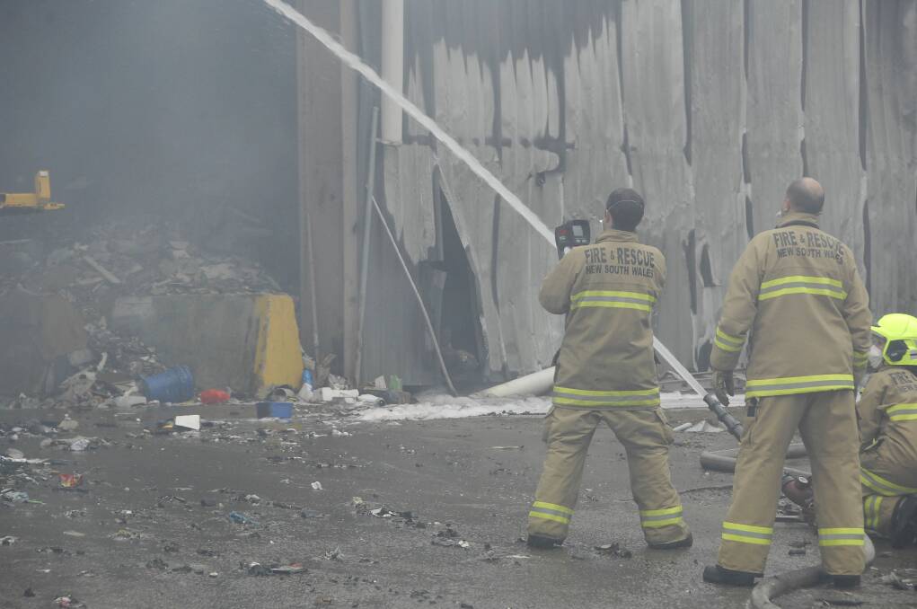 Clean up: Fire crews on the scene several hours after the fire was extinguished. Picture: Michael Szabath